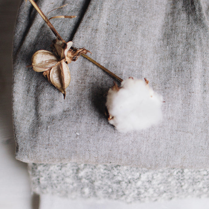 Cotton boll resting on layered natural fabric